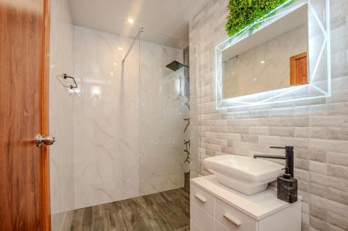 a white bathroom with a sink and a shower at Holiday home with indoor fireplace in Pamporovo