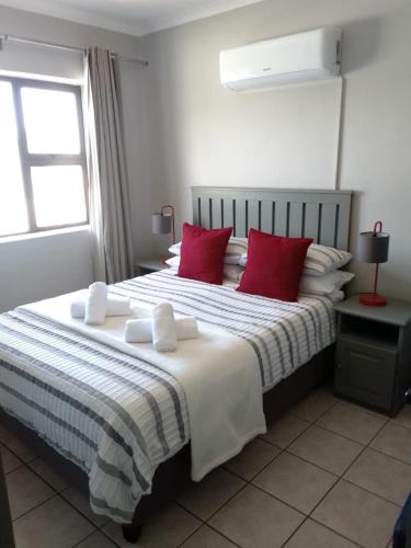 a bedroom with a large bed with red pillows at Sedgefield in Sedgefield