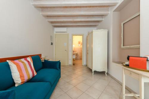 a living room with a blue couch in a room at Le Rêve - Lake view rooms in Sirmione