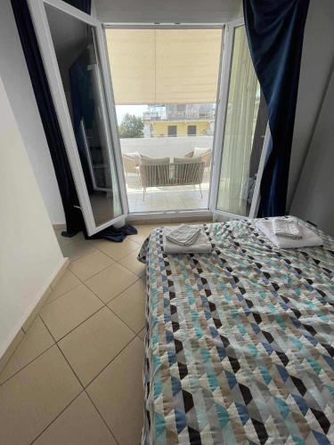 a bedroom with a bed and a large window at Relax INN Sea and Olympus View in Nea Kallikrateia