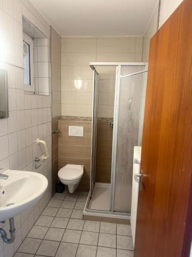 ein Badezimmer mit Dusche, Toilette und Waschbecken in der Unterkunft M2 Rooms in Lübeck