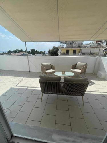a patio with chairs and a table on a roof at Relax INN Sea and Olympus View in Nea Kallikrateia