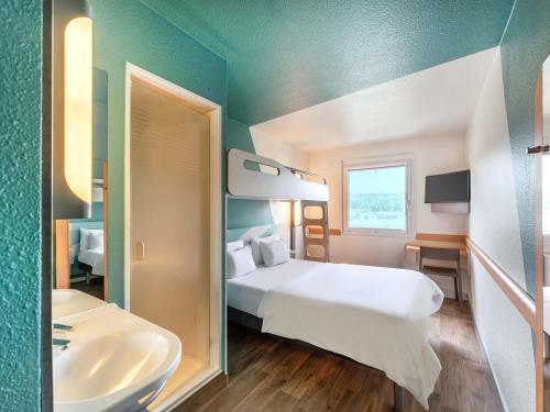 a hotel room with a bed and a sink at B&B HOTEL Braunschweig-West in Braunschweig