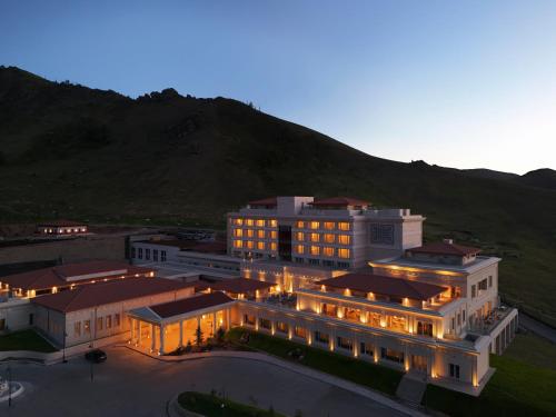 a large building with lights in front of a mountain at Ayan Zalaat in Ulaanbaatar
