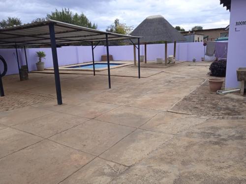 a patio with a canopy and a swimming pool at Tsoga OTirele guesthouse in Matrooster