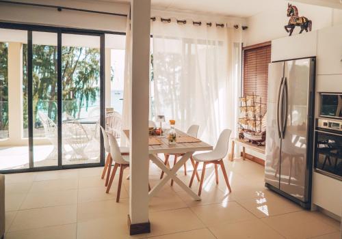 a kitchen and dining room with a table and chairs at Ayami Bay in Flic-en-Flac
