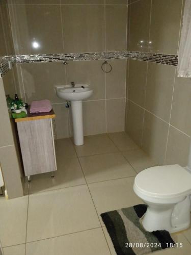 a bathroom with a toilet and a sink at Tsoga OTirele guesthouse in Matrooster