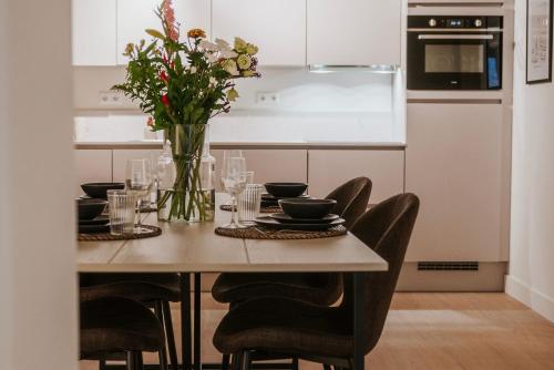 a dining room table with chairs and a vase of flowers at Naest - Authentic Escapes City House Nijmegen in Nijmegen