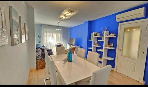 un comedor con una mesa blanca y paredes azules en Atardeceres en Bajoguía, en Sanlúcar de Barrameda