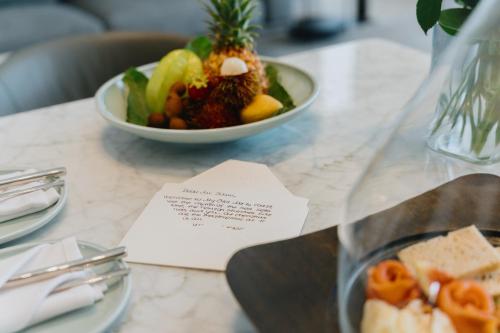 a table with a bowl of fruit and a plate of food at My Ōtel North Coast - Adult Only in Al Dabaa