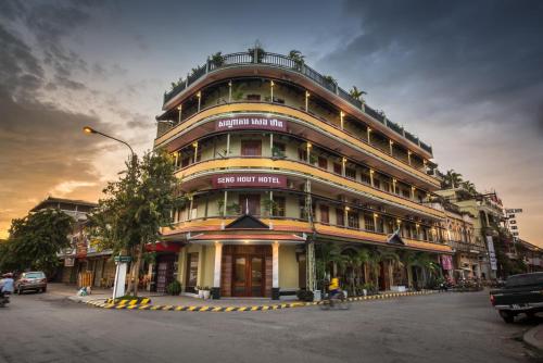 a large building on the corner of a street at Seng Hout Hotel in Battambang
