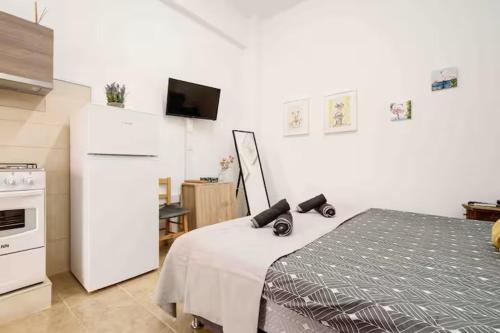 a kitchen with a white refrigerator and a bed at Сozy and traditional - EC Studios in Larnaka