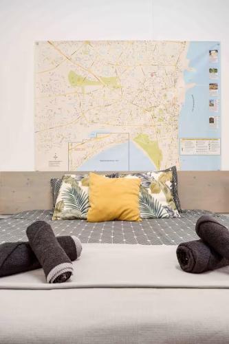 a bed with pillows and a map on the wall at Сozy and traditional - EC Studios in Larnaka
