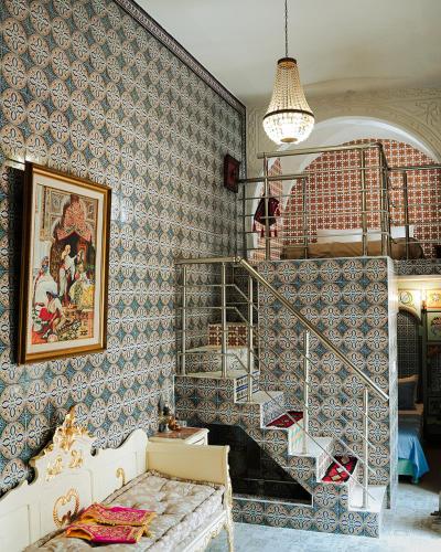 a room with a staircase with blue and white wallpaper at DAR EL HAMRA in Mahdia