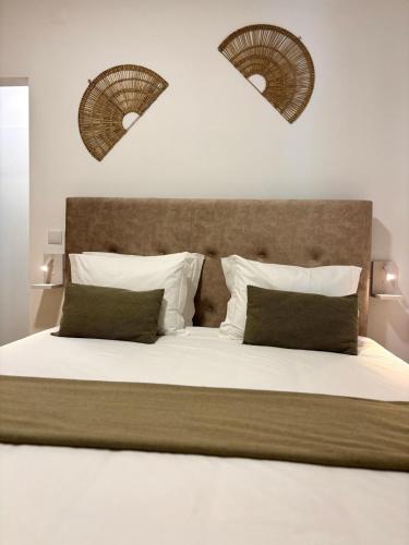 a bedroom with a large bed with white sheets and pillows at Casa Marguerite Gym and Hammam by Rentallido in Caniço