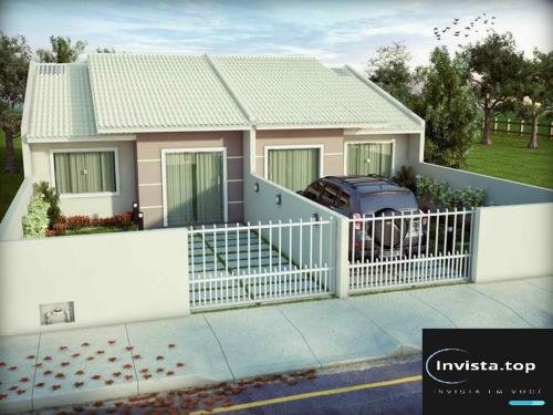 a house with a white fence and a car in it at Casa 72 m2 Litoral perto praias in Guaratuba