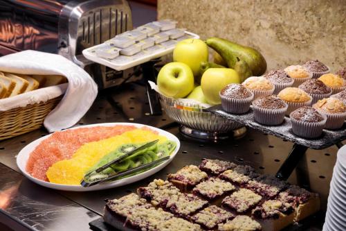 a table topped with different types of food and fruit at Natsionalny Hotel in Kyiv