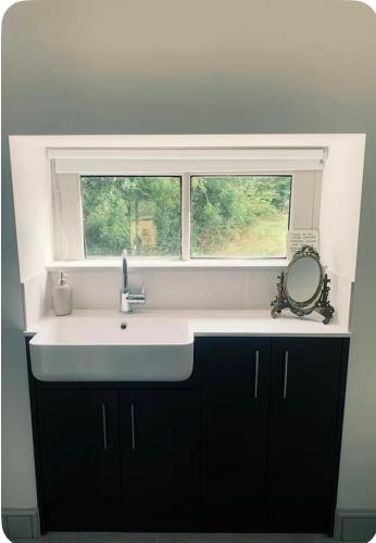 a sink in a kitchen with a window at The Hayloft- Cosy cottage in Mendip AONB in South Widcombe
