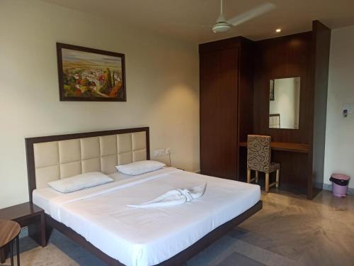 a bedroom with a large white bed in a room at Hotel Shiva Palace in Sibsāgar