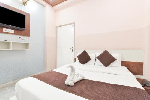 Un dormitorio con dos camas y un televisor de pantalla plana. en Arya Inn, en Jaipur