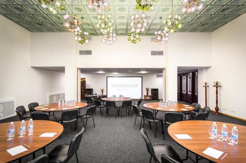 a room with tables and chairs and a projection screen at Natsionalny Hotel in Kyiv