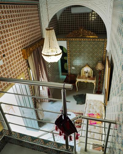 a balcony with a chandelier and a room at DAR EL HAMRA in Mahdia