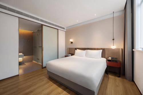 a large white bed in a hotel room at 上海浦东机场华美达安可酒店-免费提供24小时浦东机场班车十分钟到达候机楼出发层 in Shanghai