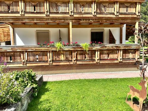 a house with a wooden porch with flowers on it at apart-gerlos in Gerlos