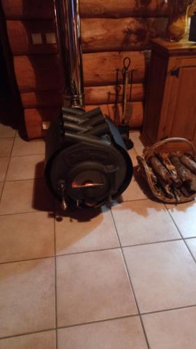 a wood stove sitting on the floor in a kitchen at Le Domaine de la Vergnolle in Roches