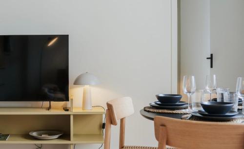 a dining room with a tv and a table with glasses at Naest - Authentic Escapes City House Nijmegen in Nijmegen
