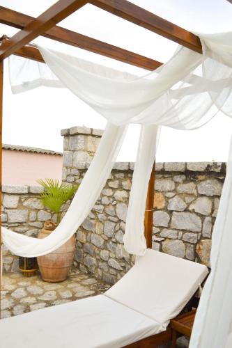 a white curtain on a patio with a stone wall at Malvazios Villas #7 in Gythio