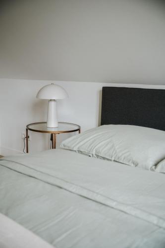 a bedroom with two beds and a table with a lamp at Naest - Authentic Escapes City House Nijmegen in Nijmegen