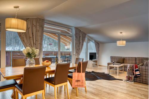 a dining room with a table and chairs at COOEE alpin Hotel Kitzbüheler Alpen in Sankt Johann in Tirol