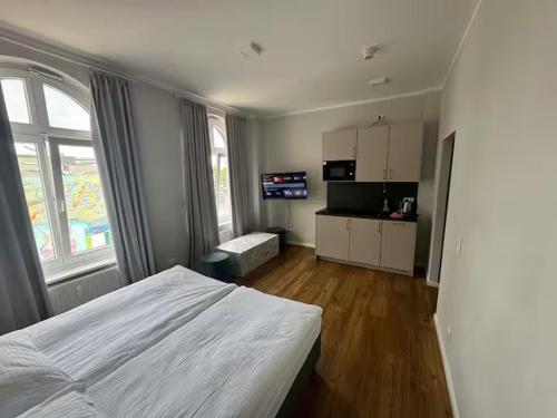 Un dormitorio con una cama blanca y un televisor. en Hamburg Hafen Wohnung, en Hamburgo