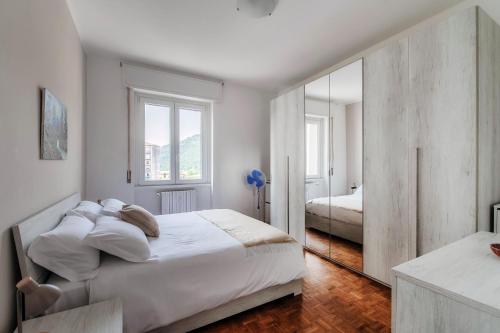 a bedroom with a large white bed and a mirror at Beyond Como by Quokka 360 - flat 10 minutes from the centre of Como in Lipomo