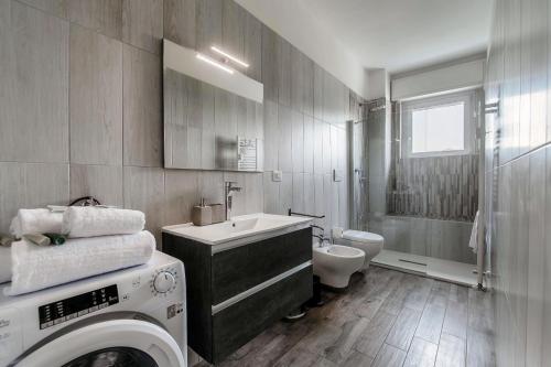 a bathroom with a washer and a washing machine in it at Beyond Como by Quokka 360 - flat 10 minutes from the centre of Como in Lipomo