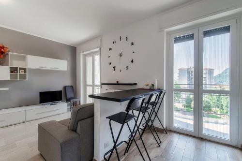 a living room with a bar with a couch and a clock at Beyond Como by Quokka 360 - flat 10 minutes from the centre of Como in Lipomo