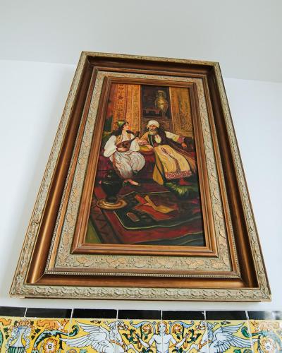 a framed picture of a painting on a wall at DAR EL HAMRA in Mahdia