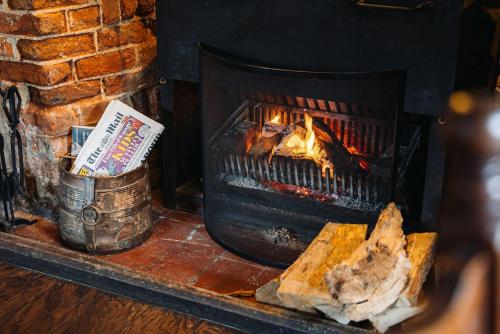 a fireplace with a piece of meat in front of it at The Coach and Horses in Oxford
