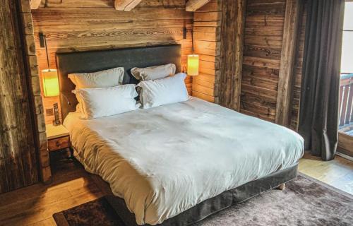 a bedroom with a large bed with wooden walls at Winter Deluxe Chalet Megève in Megève