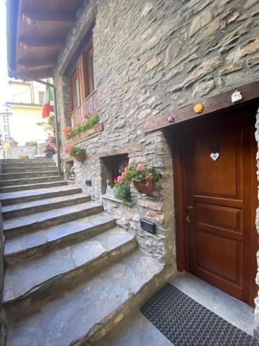 a stone building with stairs next to a wooden door at Maison Maribel in Pré-Saint-Didier