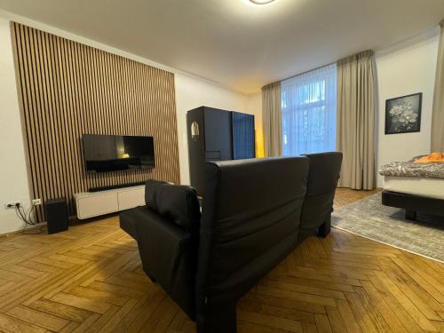 a living room with a couch and a flat screen tv at Isartor Rooms - SHARED BATHROOM in Munich