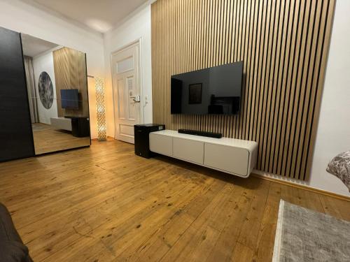 a living room with a flat screen tv on a wall at Isartor Rooms - SHARED BATHROOM in Munich