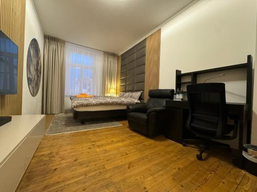 a living room with a chair and a desk and a bed at Isartor Rooms - SHARED BATHROOM in Munich
