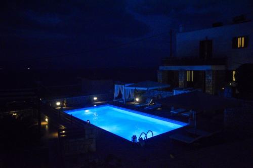 a large swimming pool at night with lights at Malvazios Villas #7 in Gythio