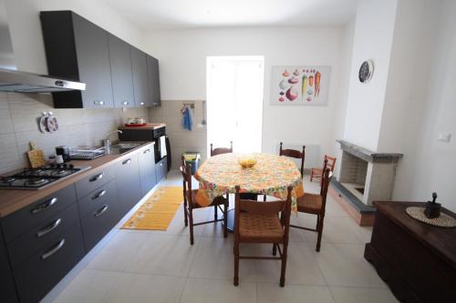 a kitchen with a table and chairs and a kitchen with a stove at Casa di Ulisse - mansarda familiare in Mandia