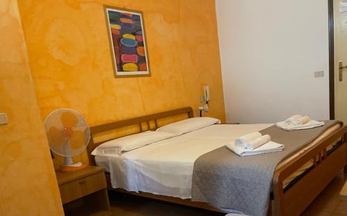 a hotel room with two beds and a fan at Hotel Luina in Stresa