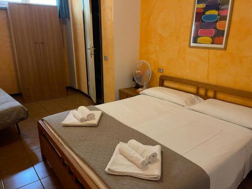 a bedroom with a bed with towels on it at Hotel Luina in Stresa