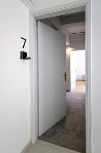 a hallway with a white door with a cross on it at Muse Studios & Apartments Aegina in Agia Marina Aegina