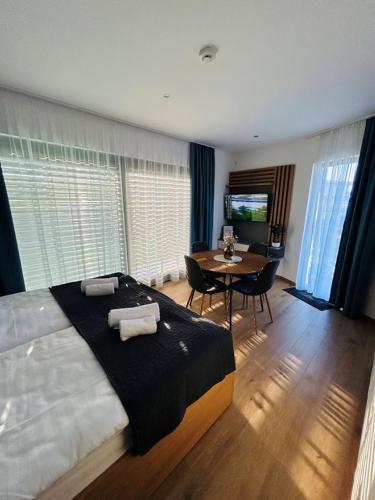 a bedroom with a large bed and a table with chairs at Cappello Vendégház in Baja